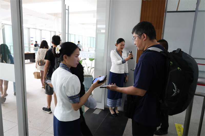 列车员在车站核验车票。老中铁路有限公司供图